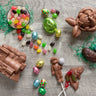 A chocolate train, a baseball player sucker with foil baseball, bunny wearing earbuds, cream egg, marshmallow egg, foiled eggs, and jelly beans 