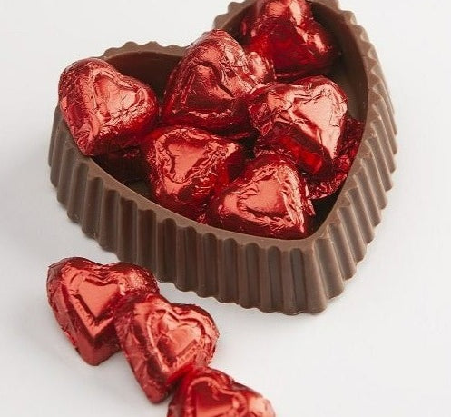 milk chocolate candy dish with small red foiled chocolates inside