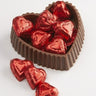 milk chocolate candy dish with small red foiled chocolates inside