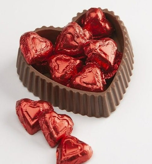 milk chocolate candy dish with small red foiled chocolates inside